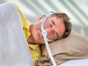 Philips CPAP Class Action Lawsuit Update May 2024 Man sleeps soundly with CPAP