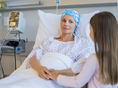 woman in hospital fighting cancer with her daughter at bedside